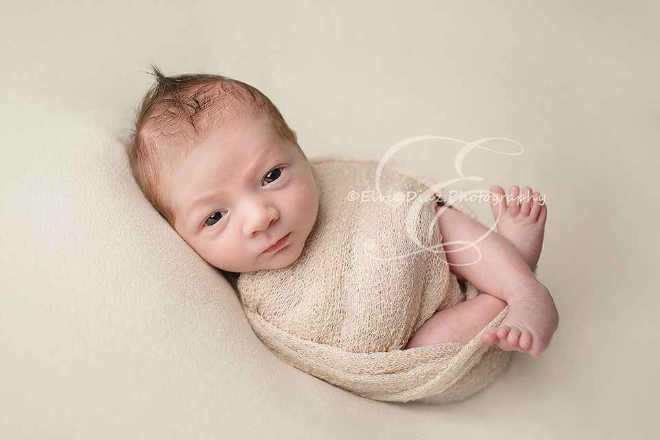 ElvieDiazPhotographyChicago-Newborn-Photographer-smiling-newborn-white-wrap-newbornboy-egg-wrapped-open-eyes-beanbag-mohawk